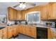 Charming kitchen with light wood cabinetry and sleek black appliances at 161 Kerr Lake Club Dr, Henderson, NC 27537