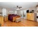Spacious main bedroom featuring hardwood floors, a ceiling fan, deck access, and a cozy wooden chest at 161 Kerr Lake Club Dr, Henderson, NC 27537