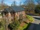 Aerial view of a brick two-story home with black shutters and professional landscaping at 201 W Park Dr, Raleigh, NC 27605