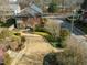 Aerial view of a brick home showcasing the landscaped grounds and stone driveway at 201 W Park Dr, Raleigh, NC 27605