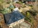 Aerial view of garage roof and beautifully landscaped backyard with greenhouse and mature trees at 201 W Park Dr, Raleigh, NC 27605