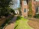 The manicured backyard features a brick path and lush greenery along the side of this house at 201 W Park Dr, Raleigh, NC 27605