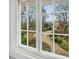 View of a garden with a stone path and lush greenery through a double-hung window at 201 W Park Dr, Raleigh, NC 27605