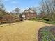 Back of the house featuring a large lawn, mature trees, and beautiful landscaping at 201 W Park Dr, Raleigh, NC 27605