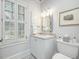 Bathroom featuring a vanity with a marble countertop, toilet, and white shutters at 201 W Park Dr, Raleigh, NC 27605