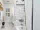 Bathroom with a shower/tub combo, patterned tile floors, and white marble backsplash at 201 W Park Dr, Raleigh, NC 27605