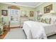 Bedroom with green walls, a light rug, and a window with plantation shutters at 201 W Park Dr, Raleigh, NC 27605
