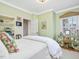 Bright bedroom featuring light green walls, hardwood floors, and a plush bed at 201 W Park Dr, Raleigh, NC 27605