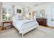 Bright bedroom with a white bed frame, patterned curtains, and wood nightstand at 201 W Park Dr, Raleigh, NC 27605