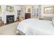 Bright bedroom with a fireplace, hardwood floors, and floral patterned curtains at 201 W Park Dr, Raleigh, NC 27605