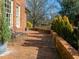 Brick patio area featuring an iron bench and manicured greenery, perfect for outdoor relaxation at 201 W Park Dr, Raleigh, NC 27605