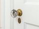 Close-up of a vintage glass doorknob with brass hardware on a white door at 201 W Park Dr, Raleigh, NC 27605