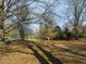 A street facing green space surrounded by mature trees, offering serene escape and a walking path at 201 W Park Dr, Raleigh, NC 27605