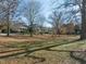 A grassy green space with mature trees providing shade, perfect for a picnic surrounded by homes at 201 W Park Dr, Raleigh, NC 27605