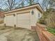 Spacious two-car garage with beige doors, brick accents, and concrete driveway at 201 W Park Dr, Raleigh, NC 27605