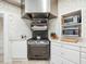 This kitchen features white cabinetry, stainless appliances, and a light neutral wallpaper at 201 W Park Dr, Raleigh, NC 27605