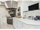 This kitchen features white cabinetry, stainless appliances, and a light neutral wallpaper at 201 W Park Dr, Raleigh, NC 27605
