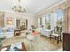 Bright living room with large windows, chandelier, and comfortable seating creating a warm, inviting atmosphere at 201 W Park Dr, Raleigh, NC 27605
