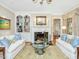 Elegant living room featuring a fireplace, built-in bookshelves, and comfortable seating arrangement at 201 W Park Dr, Raleigh, NC 27605
