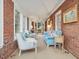 Inviting sunroom featuring exposed brick, comfortable seating, and ample natural light for relaxation at 201 W Park Dr, Raleigh, NC 27605