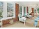 Cozy sunroom featuring brick walls, multiple windows and comfortable chairs inviting relaxation and natural light at 201 W Park Dr, Raleigh, NC 27605