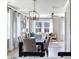 Bright and airy dining room featuring a modern chandelier and views of the wooded landscape at 2013 Trident Maple Ln, Chapel Hill, NC 27517