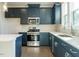 Well-lit kitchen with stainless steel appliances, blue cabinets and herringbone-patterned backsplash at 2019 Trident Maple Ln, Chapel Hill, NC 27517