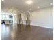 Open-concept living room with hardwood floors flowing into a kitchen with dark cabinets and an island at 2019 Trident Maple Ln, Chapel Hill, NC 27517