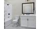 Modern white bathroom with black accents, including a shower, toilet, vanity, and mirror at 2021 Trident Maple Ln, Chapel Hill, NC 27517