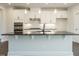 Contemporary kitchen boasts white cabinetry, stainless steel appliances, granite counters, and stylish lighting at 2021 Trident Maple Ln, Chapel Hill, NC 27517