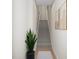 Hallway with carpeted stairs and natural wood handrail in a neutral setting with modern art at 2021 Trident Maple Ln, Chapel Hill, NC 27517