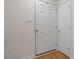 Hallway with white doors and wood flooring with light switch against the wall at 2607 Nation Ave, Durham, NC 27707