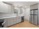 Well lit kitchen features stainless steel appliances, light wood floors, grey cabinetry, and a breakfast bar at 2607 Nation Ave, Durham, NC 27707