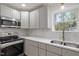 Bright kitchen featuring stainless steel appliances, grey cabinetry, and tiled backsplash at 2607 Nation Ave, Durham, NC 27707