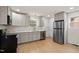 Well lit kitchen features stainless steel appliances, light wood floors, grey cabinetry, and a breakfast bar at 2607 Nation Ave, Durham, NC 27707