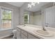 Bright bathroom with a double sink vanity, tile flooring, and a window view at 270 S Ridge Dr, Garner, NC 27529