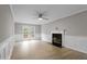 Living room with wood-look floors, wainscoting, fireplace, French doors to deck, and ceiling fan at 270 S Ridge Dr, Garner, NC 27529