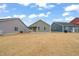 Expansive backyard with well-maintained lawn and view of neighboring homes under a bright blue, partly cloudy sky at 303 Bella Sq, Smithfield, NC 27577