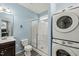 Bathroom with a walk-in shower and stacked washer and dryer, all in a neutral color palette at 303 Bella Sq, Smithfield, NC 27577