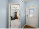 Bright entryway featuring a white front door and open view to a living room with blue walls and a ceiling fan at 303 Bella Sq, Smithfield, NC 27577