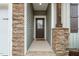 Inviting entryway with stone pillar accents, a wooden front door, and a pathway leading to the home's entrance at 303 Bella Sq, Smithfield, NC 27577
