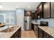 Stylish kitchen featuring stainless steel appliances, dark cabinets, granite countertops, and a central island with seating at 303 Bella Sq, Smithfield, NC 27577