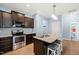 Contemporary kitchen boasts stainless steel appliances, dark cabinets, and a central granite island with stylish bar stools at 303 Bella Sq, Smithfield, NC 27577