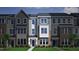 Charming townhome showcasing a blend of gray siding, brick accents, and manicured green lawn at 319 Chesapeake Commons St # 103, Garner, NC 27529