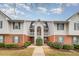 A charming townhouse with white siding, red brick accents, and manicured landscaping at 3322 Wellington Ridge Loop, Cary, NC 27518