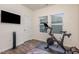 Exercise room with modern exercise bike, mounted TV, hardwood floors, and plenty of light at 3516 Cider Cv, Apex, NC 27502