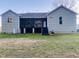 View of the backyard with a covered porch and steps down to a grassy lawn at 381 Reams Dr, Middlesex, NC 27557