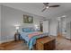 Cozy bedroom featuring hardwood floors, ceiling fan, bedside lamps and a decorative chest at the foot of the bed at 381 Reams Dr, Middlesex, NC 27557