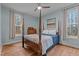 Comfortable bedroom featuring a four-poster bed, two windows, light blue walls, hardwood floors and soft natural light at 381 Reams Dr, Middlesex, NC 27557