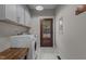 Functional laundry room with modern washer and dryer, wooden bench, overhead cabinets, and exterior access at 381 Reams Dr, Middlesex, NC 27557